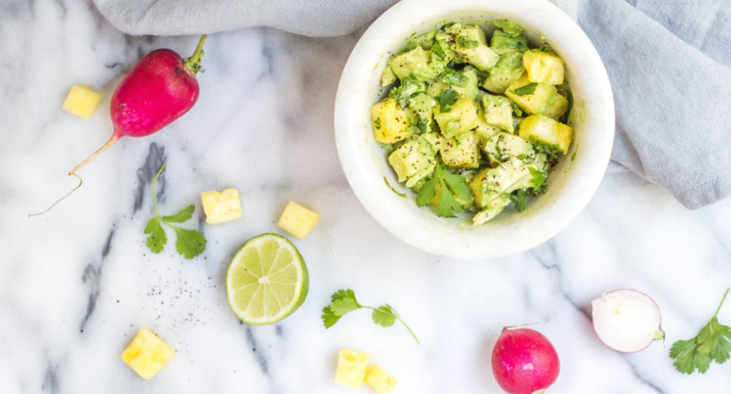 fresh guacamole with ingredients around counter